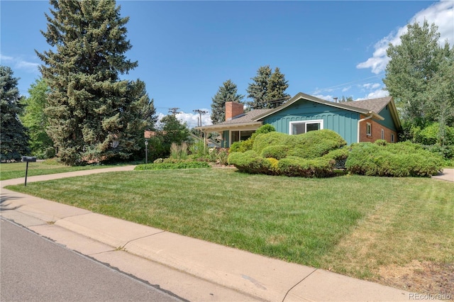 815 Hoyt St, Lakewood, CO 80215 - view of front of home featuring board and batten siding, a front yard, and a chimney
