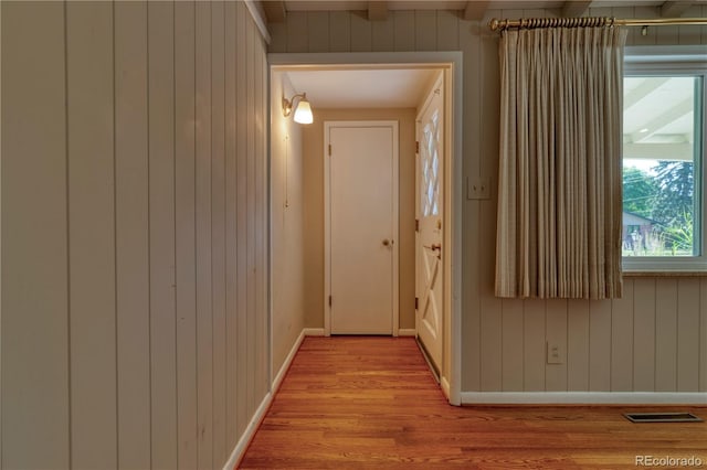 815 Hoyt St, Lakewood, CO 80215 - hallway featuring light wood finished floors, wooden walls, and beam ceiling