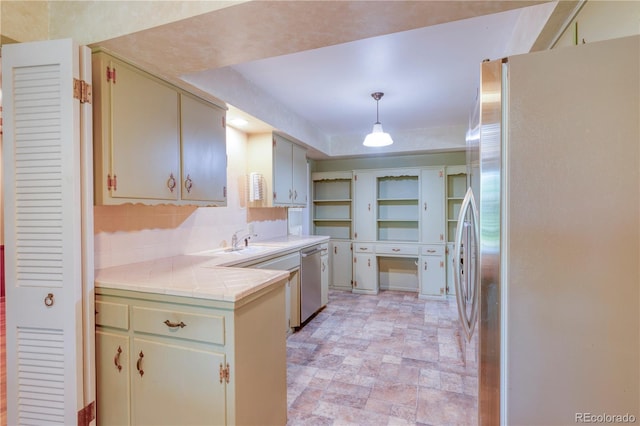 815 Hoyt St, Lakewood, CO 80215 - kitchen featuring appliances with stainless steel finishes, tile counters, stone finish floors, hanging light fixtures, and tasteful backsplash