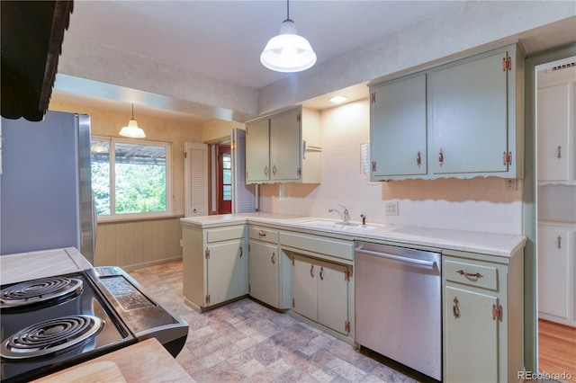 815 Hoyt St, Lakewood, CO 80215 - kitchen with appliances with stainless steel finishes, a peninsula, hanging light fixtures, stone finish flooring, and backsplash