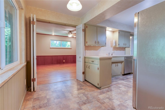 815 Hoyt St, Lakewood, CO 80215 - kitchen featuring stainless steel appliances, stone finish flooring, light countertops, wainscoting, and a ceiling fan