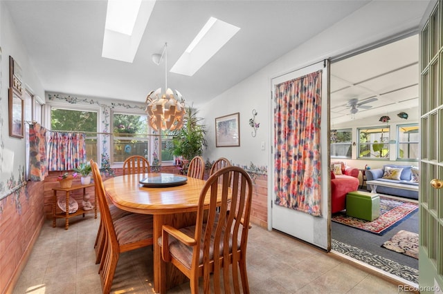 dining area with a chandelier, healthy amount of natural light, a skylight, and light tile patterned floors