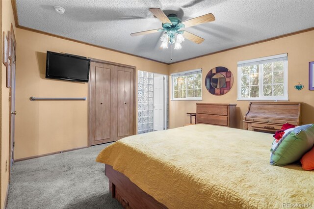 carpeted bedroom featuring ornamental molding, a textured ceiling, a ceiling fan, and baseboards