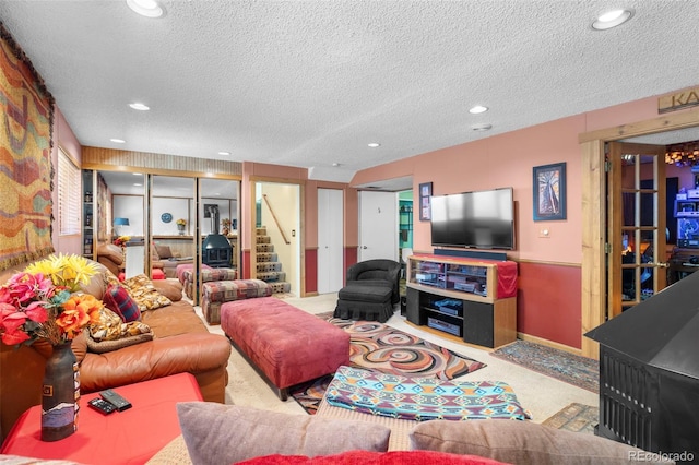 living room with carpet, a textured ceiling, stairs, and recessed lighting
