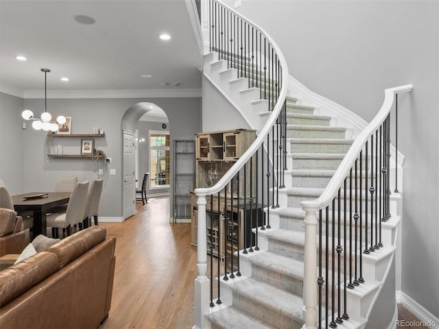 425 Steele St, Denver, CO 80206 - stairway with arched walkways, wood finished floors, recessed lighting, ornamental molding, and a chandelier