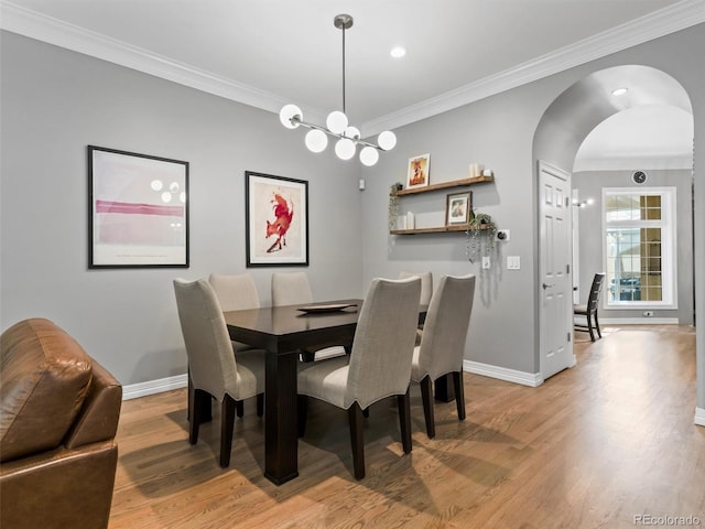 425 Steele St, Denver, CO 80206 - dining space with light wood-style flooring, ornamental molding, arched walkways, and a chandelier