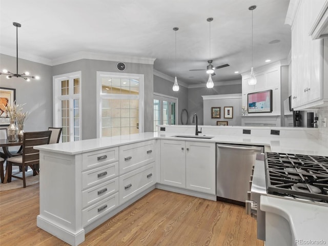 425 Steele St, Denver, CO 80206 - kitchen featuring stainless steel dishwasher, light countertops, white cabinets, decorative light fixtures, and light wood finished floors