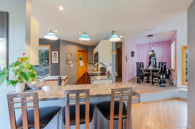 kitchen with baseboard heating, light wood-style flooring, recessed lighting, stainless steel electric stove, and white cabinets
