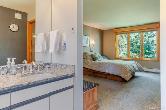 carpeted bedroom with a baseboard heating unit and a sink