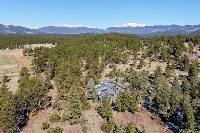 birds eye view of property featuring a mountain view and a wooded view