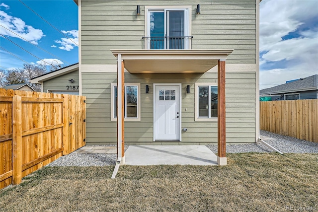 doorway to property featuring a patio area and a lawn