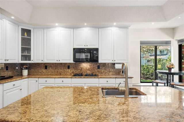 kitchen with black appliances, white cabinets, and sink