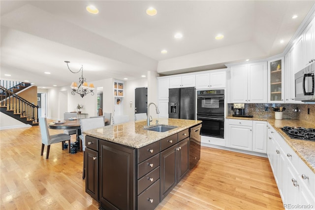 kitchen with black appliances, sink, an inviting chandelier, white cabinetry, and dark brown cabinetry