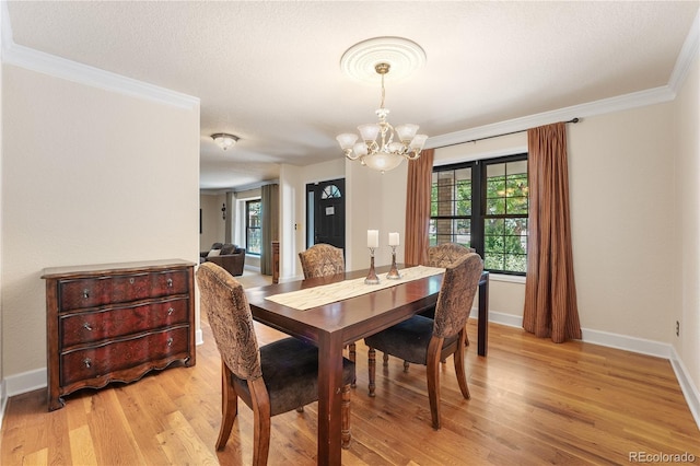 dining room featuring light hardwood / wood-style floors, ornamental molding, and an inviting chandelier