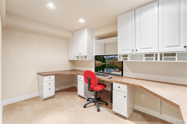 office with built in desk and light colored carpet