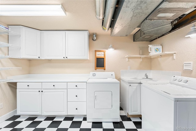 laundry area featuring cabinets, sink, and washing machine and dryer