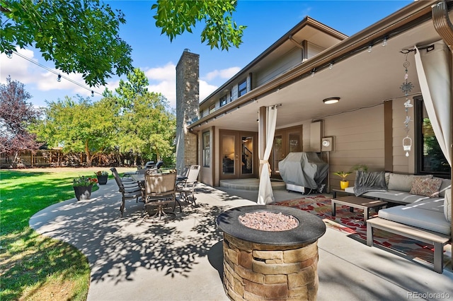 view of patio / terrace with area for grilling and an outdoor living space with a fire pit