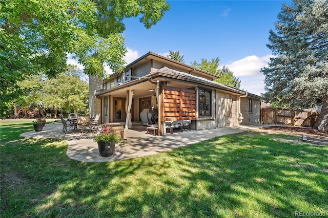 rear view of property with a yard and a patio