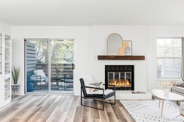 sitting room featuring hardwood / wood-style floors, a healthy amount of sunlight, and a fireplace