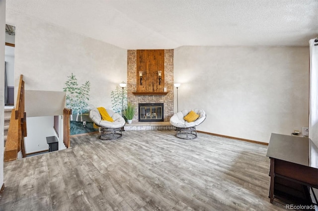 unfurnished living room featuring hardwood / wood-style floors, a fireplace, and a textured ceiling