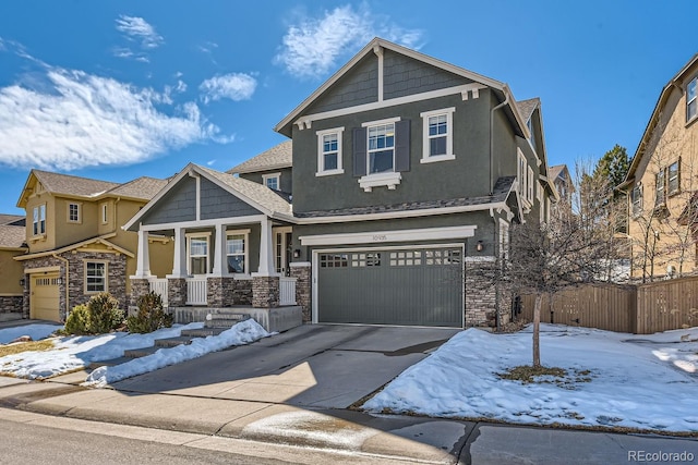 craftsman house featuring concrete driveway, stone siding, an attached garage, covered porch, and stucco siding