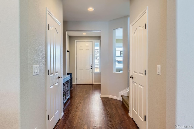 doorway to outside with dark wood-type flooring and baseboards