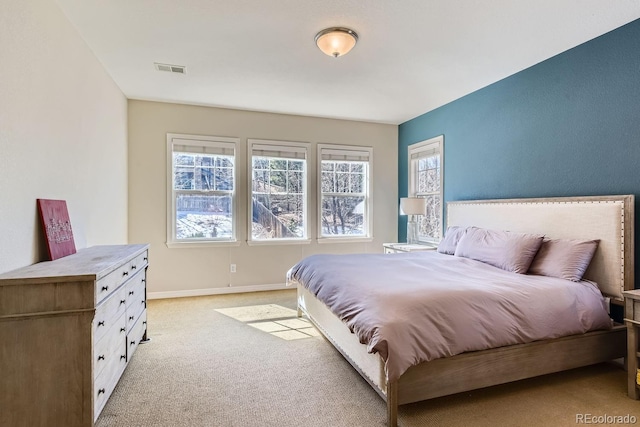 bedroom with light carpet, visible vents, and baseboards