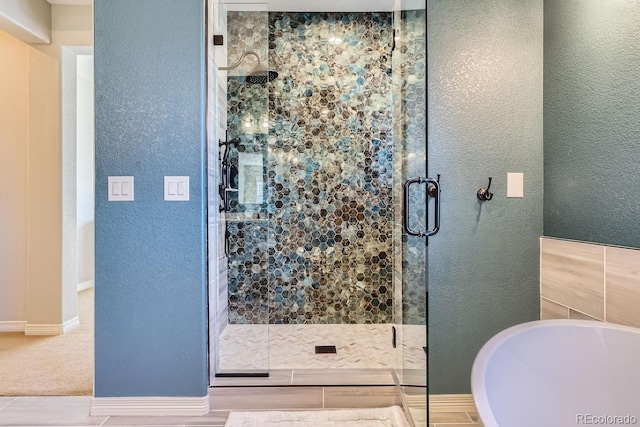 full bath with a soaking tub, a textured wall, and a shower stall