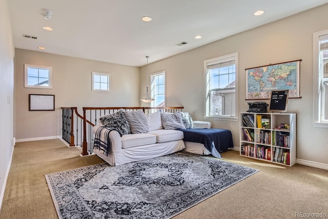 living area with a wealth of natural light, visible vents, and baseboards