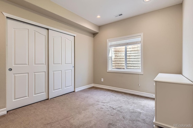 unfurnished bedroom featuring baseboards, visible vents, carpet, a closet, and recessed lighting