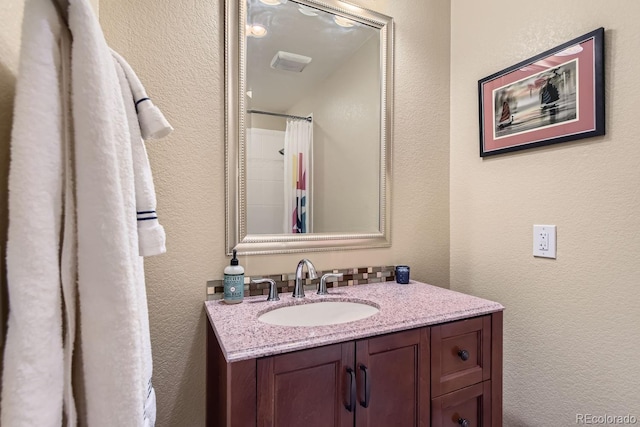 bathroom with a shower with shower curtain, a textured wall, visible vents, and vanity