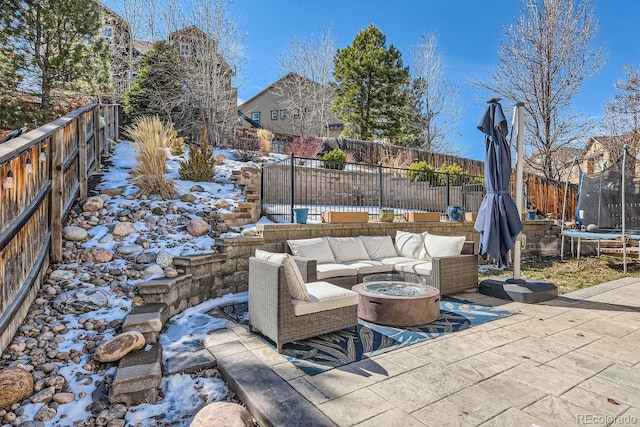 view of patio with a trampoline, a fenced backyard, and an outdoor hangout area