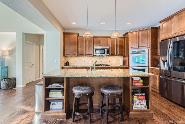 kitchen featuring stainless steel appliances, decorative backsplash, open shelves, dark wood finished floors, and a center island with sink