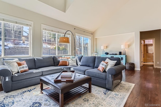 living area featuring high vaulted ceiling, dark wood finished floors, and baseboards