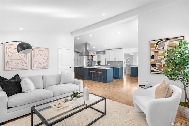 living area with high vaulted ceiling, recessed lighting, and light wood-style floors