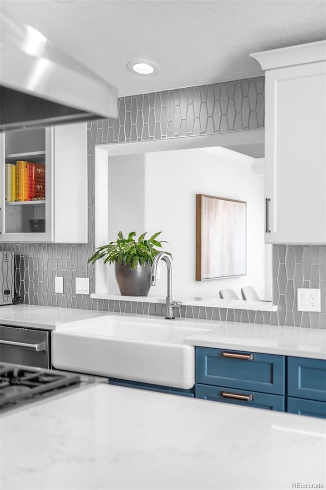 kitchen with blue cabinets, light countertops, and a sink