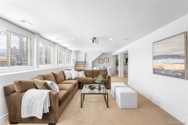 living room featuring visible vents, baseboards, stairway, a textured ceiling, and recessed lighting