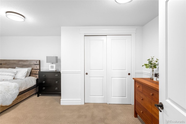 bedroom featuring a closet and light colored carpet