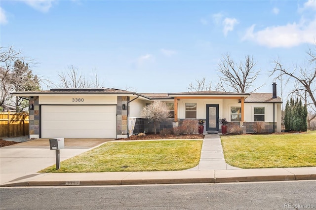 view of front of property featuring a garage, fence, concrete driveway, stucco siding, and a front yard