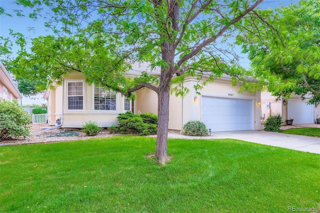 view of front of property featuring a front yard, concrete driveway, stucco siding, and an attached garage