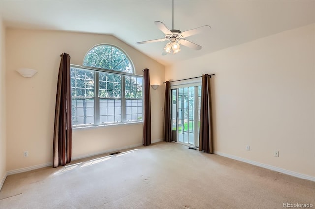 empty room with lofted ceiling, ceiling fan, and light carpet