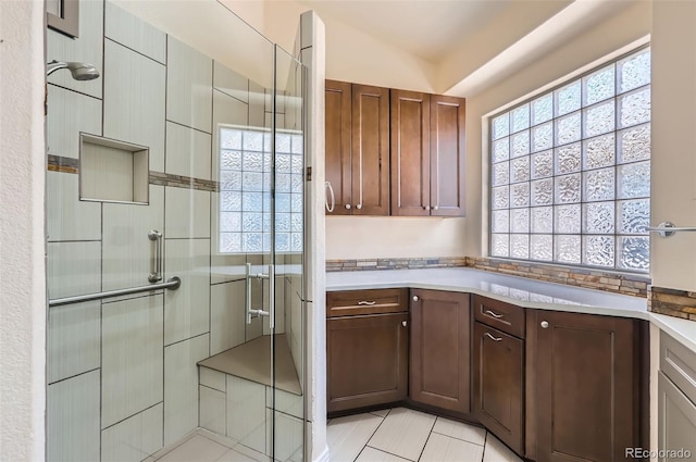full bathroom with a stall shower and tile patterned flooring