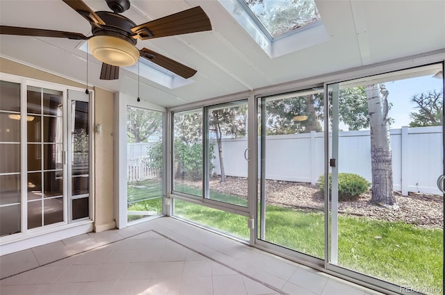 unfurnished sunroom with a skylight, tile patterned flooring, a ceiling fan, and vaulted ceiling