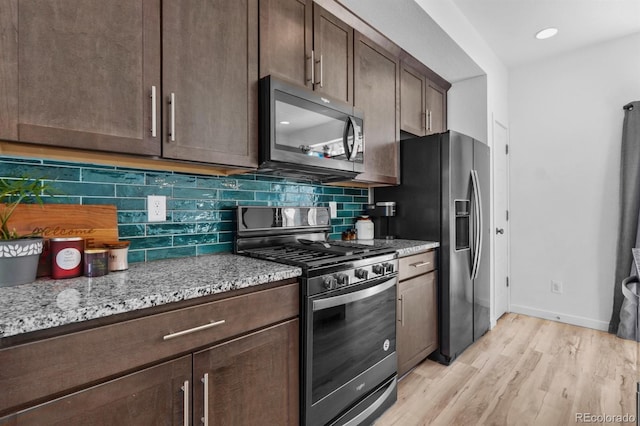 5704 Callan Dr, Colorado Springs, CO 80927 - kitchen with light hardwood / wood-style flooring, backsplash, dark brown cabinets, light stone countertops, and stainless steel range with gas cooktop