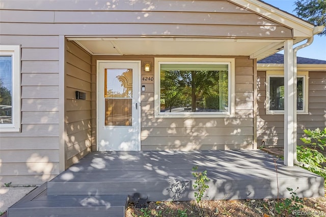 view of exterior entry featuring a wooden deck