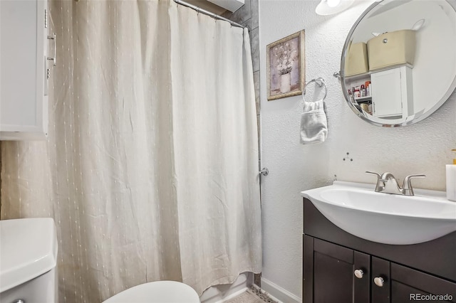 bathroom featuring toilet, vanity, and curtained shower