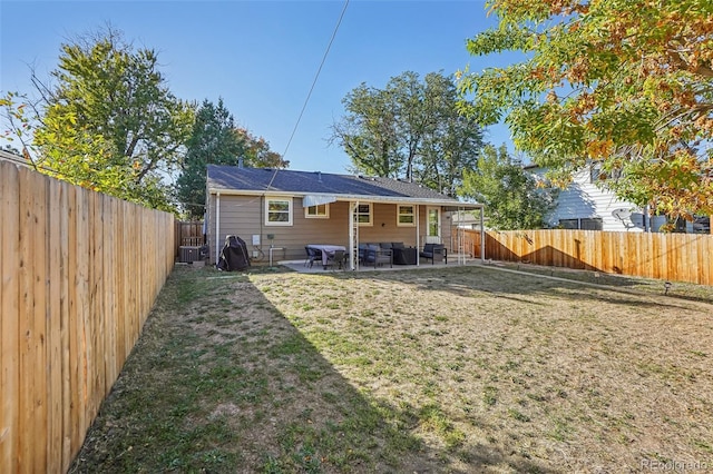 rear view of house with a yard and a patio