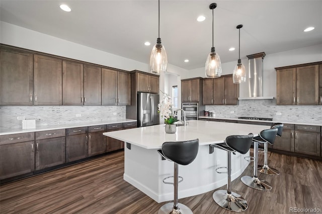 kitchen featuring wall chimney range hood, stainless steel fridge with ice dispenser, light countertops, dark wood-type flooring, and backsplash