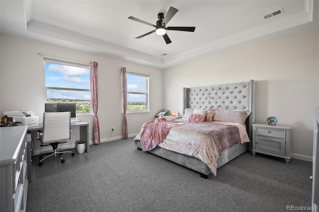 bedroom featuring visible vents, a raised ceiling, baseboards, and dark colored carpet