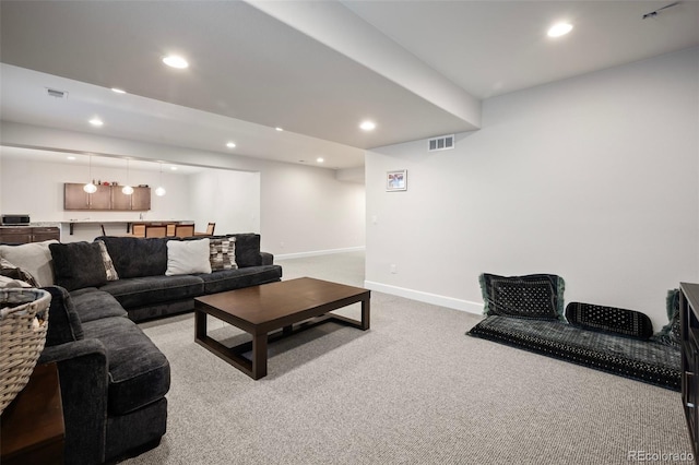 carpeted living area with baseboards, recessed lighting, and visible vents